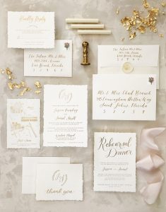 custom invitation suite featuring gold foil on cotton paper with hand deckled edges